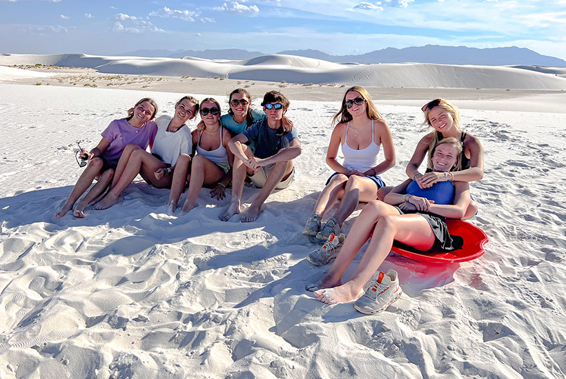 teens sitting in the sand at White Sands National Park