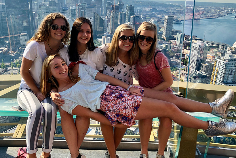 girls having fun in the space needle overlooking Seattle